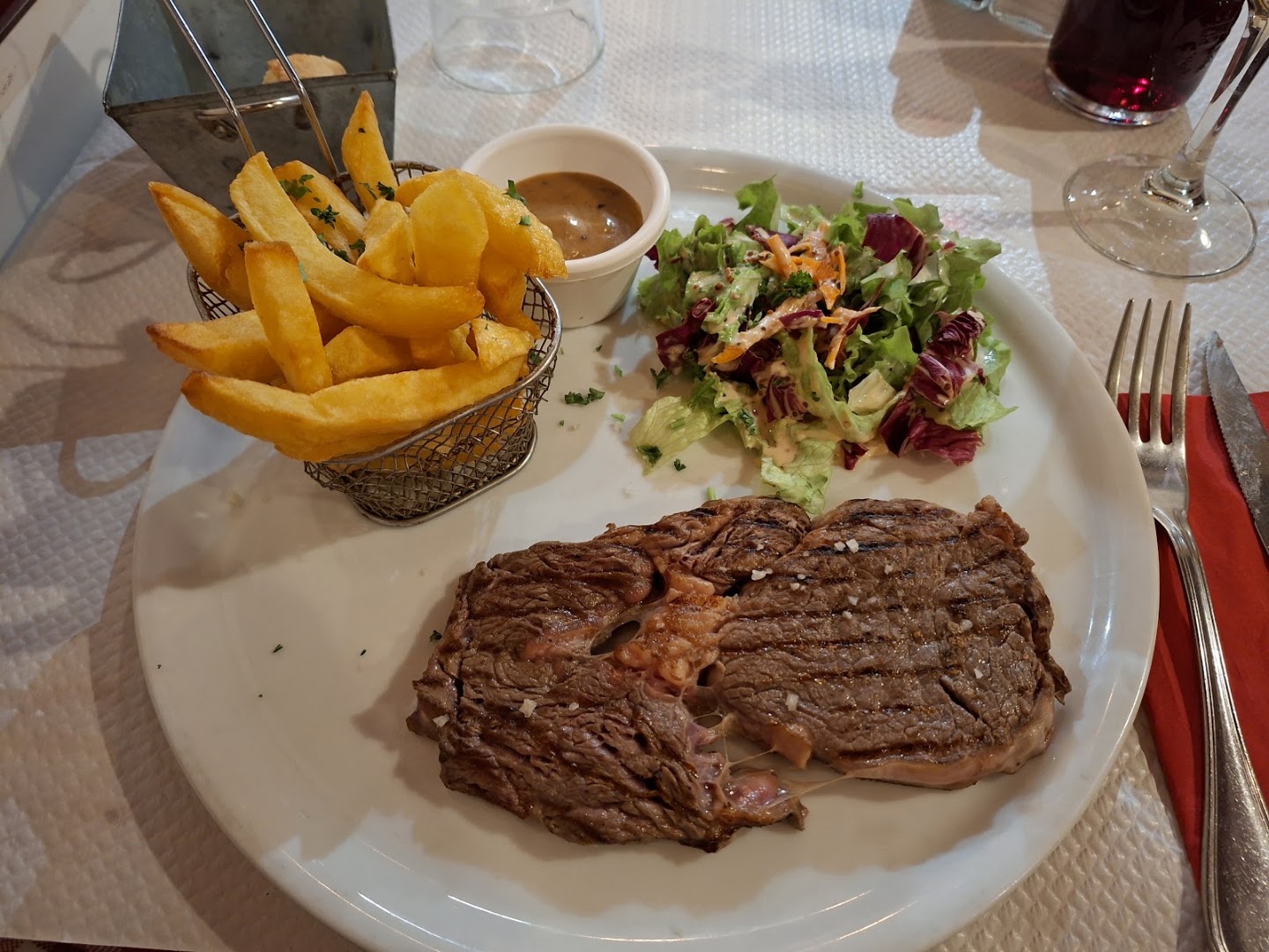 Steak, frites et salade servis sur une assiette